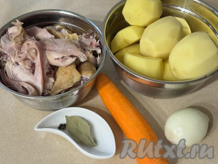 Подготовить продукты для приготовления картошки, тушёной с копчёной курицей. Копчёную курицу нарезать на части. Для этого блюда можно взять любые части копчёной курицы. При желании можно отделить мясо от костей, я этого делать не стала. Картошку, лук и морковь почистить. Очищенный картофель выложить в миску и залить полностью водой, чтобы он не потемнел.