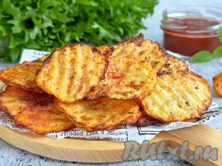 Переложить готовые картофельные чипсы из чаши аэрогриля на тарелку и приготовить следующую партию.