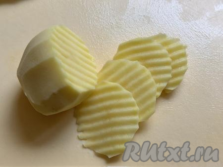 Картошку почистить, нарезать на тонкие кружочки (ориентировочно толщиной 2-3 миллиметра). Я нарезала картофель рифлёным ножом. Желательно, чтобы все кружочки были примерно одинаковой толщины, чтобы они равномерно запеклись в аэрогриле.