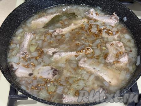 Перемешать гречку с рёбрами, довести бульон до кипения, уменьшить огонь до минимума. Закрыть сковороду крышкой, готовить минут 20-25 (до полного впитывания воды).&nbsp;