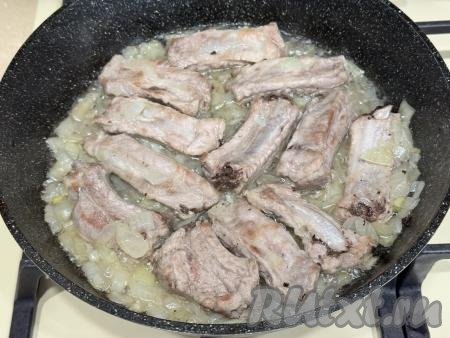 Обжарить рёбра с луком в течение 5 минут (до прозрачности лука), иногда перемешивая, на среднем огне.&nbsp;