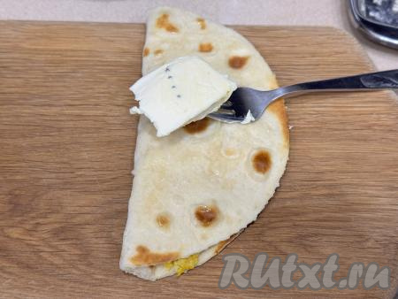 Накрыть сторону с начинкой чистой стороной лепёшки. Сразу обильно смазать горячий кыстыбый с двух сторон сливочным маслом. Выложить на тарелку. Благодаря маслу лепёшка станет более нежной и мягкой.