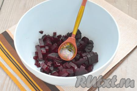 Варёную свеклу очищаем, нарезаем на маленькие кубики, перекладываем в салатник, сразу добавляем 1 столовую ложку растительного масла, перемешиваем. Благодаря предварительному смешиванию с растительным маслом, свекла в дальнейшем не будет сильно окрашивать остальные ингредиенты винегрета в бордовый цвет.
