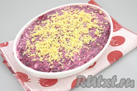 Украшаем салат "Селёдка под шубой", приготовленный без картошки, ранее отложенным желтком, натёртым на мелкой тёрке. Отправляем салат пропитаться в холодильник хотя бы на 35-45 минут.