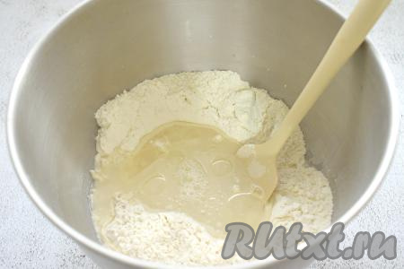 В получившееся углубление в смеси муки и дрожжей вливаем растительное масло и тёплую воду (температура воды должна быть ориентировочно 38-39 градусов, если вода будет выше 42 градусов, дрожжи могут погибнуть).