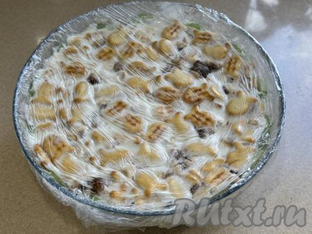 Поставить миску с тортом из печенья "Рыбки" с бананом и киви&nbsp;в холодильник на ночь. На следующий день убрать плёнку, покрывающую торт сверху.