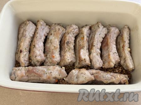 Выложить обжаренные свиные рёбрышки поверх гречки.&nbsp;