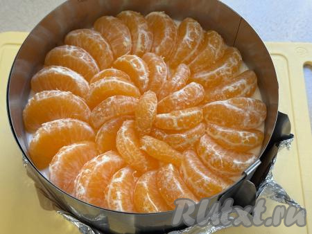 Поверх застывшей творожной начинки выложить дольки мандарина.&nbsp;