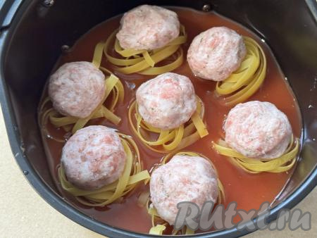 Влить соус в чашу аэрогриля с гнёздами&nbsp;из макарон и фаршем. Соус должен практически полностью покрывать макаронные гнёзда.