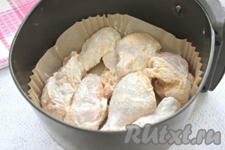 Чашу аэрогриля я застелила специальным вкладышем из пергамента. Если такого вкладыша нет, тогда нужно немного смазать решётку аэрогриля растительным маслом. Выкладываем в чашу аэрогриля в один слой замаринованные в сметане части курицы.