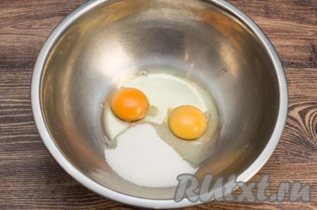 В миску вбить сырые яйца, всыпать сахар.