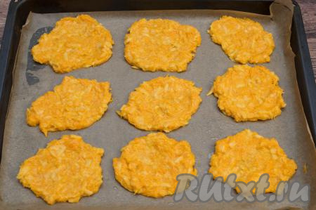 Беря тесто по 1 столовой ложке с горкой, выкладывать его на застеленный противень, формируя достаточно плоские округлые оладьи.
