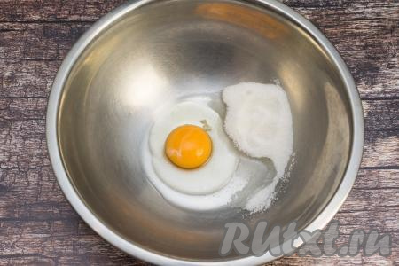 В миску всыпать соль и сахар, вбить сырое яйцо.