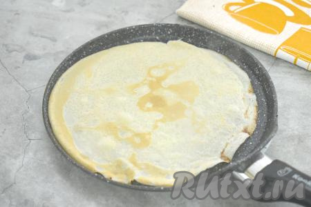 Поверхность сковороды (у меня диаметр сковородки 22 сантиметра) смазываем растительным маслом, хорошо разогреваем, затем вливаем небольшой половник теста. Сразу равномерно распределяем блинное тесто по дну сковороды. Жарим блин на среднем огне до подрумянивания с двух сторон (ориентировочно по 1 минуте с каждой стороны). Готовый блинчик перекладываем со сковороды на тарелку. Перемешивая тесто перед жаркой очередного блина и смазывая сковороду по мере необходимости, постепенно жарим все тонкие, эластичные блинчики, складывая их стопочкой на тарелку. Из предложенного количества ингредиентов я пожарила 12 блинов.