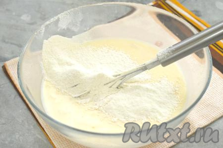 В получившуюся молочно-яичную смесь просеиваем частями пшеничную муку, каждый раз хорошо перемешивая венчиком. Добавляя постепенно муку, учитывайте, что тесто должно получиться однородным, не слишком жидким, напоминающим кефир средней жирности.