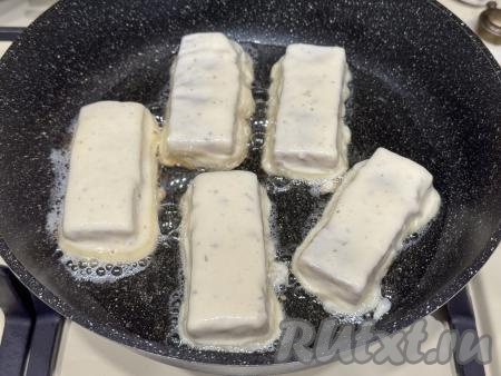 В сковороду влить растительное масло, разогреть, выложить кусочек брикета минтая, покрытый кляром. Выложить в сковороду ещё несколько брикетов в кляре в один слой. Покрывать кляром нужно столько частей минтая, сколько одновременно поместятся в сковороду. Заранее покрывать брикеты кляром не нужно.