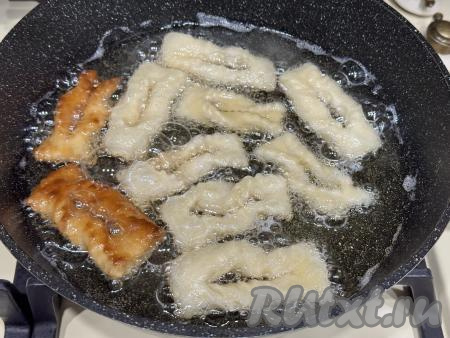 В сковороду влить достаточное количество растительного масла (масло должно доходить до середины хвороста), разогреть на достаточно сильном огне, уменьшить огонь до среднего. Выложить хворост в сковороду в один слой и жарить с двух сторон до золотистого цвета.