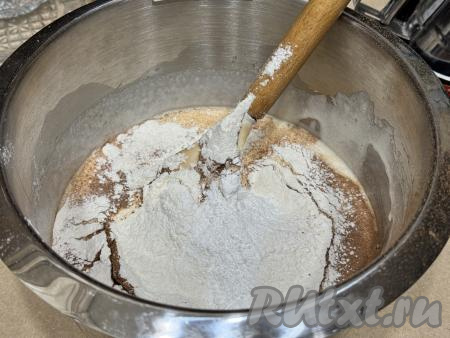 Сразу же всыпать разрыхлитель и 150 грамм просеянной муки, перемешать тесто лопаткой до однородности.