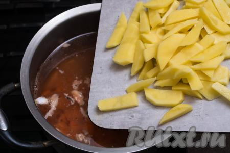 Сразу же выложить в кастрюлю картошку, нарезанную на средние брусочки.