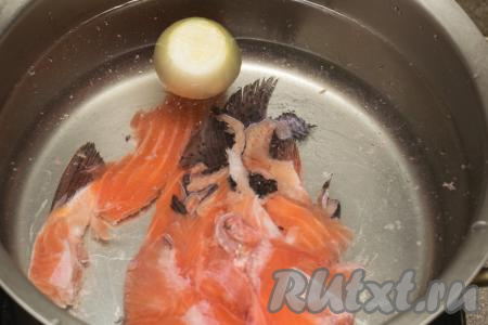 Обрезь форели и очищенную луковицу выложить в касрюлю, залить 2,5 литрами воды, поставить на огонь.