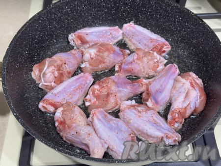 Разогреть в сковороде растительное масло, выложить куриные крылышки в один слой.&nbsp;