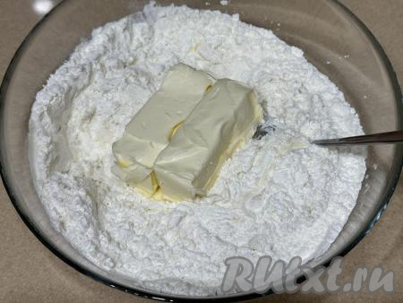 Перемешать массу столовой ложкой до однородности, добавить сливочное масло комнатной температуры. Вначале вмешивать масло столовой ложкой (или вилкой), а затем продолжить замешивать тесто руками.
