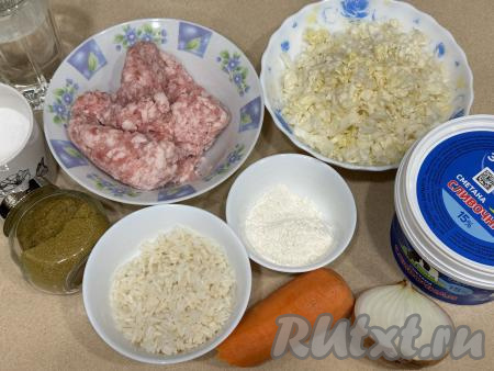 Подготовить продукты для приготовления ленивых голубцов в сметане в духовке. Рис промыть водой, затем выложить в кастрюлю с кипящей водой, перемешать и отварить до готовности (в течение минут 20, рисинки должны стать мягкими), затем откинуть на сито. Оставить рис в сите, чтобы стекла вода и он остыл. При желании можно взять и грамм 100 риса, оставшегося с обеда или ужина. Фарш можно использовать любой (у меня - свиной). Фарш можно приготовить в домашних условиях, пропустив через мясорубку один или несколько видов мяса, можно взять и покупной фарш. Лук и морковь почистить. Белокочанную капусту помыть водой, мелко нарезать.