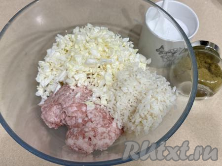 В глубокую миску выложить фарш, добавить рис и нарезанную капусту.&nbsp;