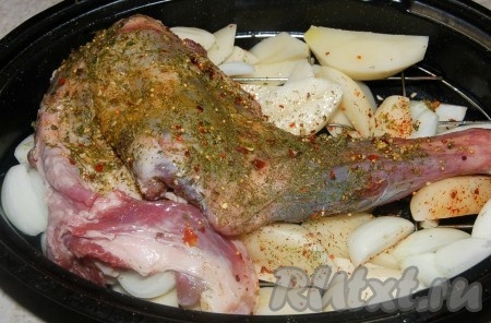 Баранью ногу выложить поверх картошки и лука, влить воду, добавить лавровые листочки в форму.
