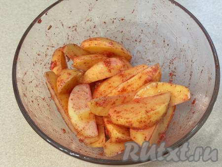 Тщательно перемешать дольки картошки, покрывая их солью и специями со всех сторон.