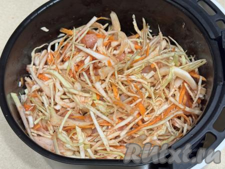 Перемешать капусту с морковью, томатным соусом и мясом курицы, установить чашу в аэрогриль. Выставить режим 180 градусов, время - 45 минут. Через каждые 10 минут чашу нужно доставать и перемешивать капусту с курицей, чтобы блюдо не подгорело и мясо с капустой равномерно протушились.