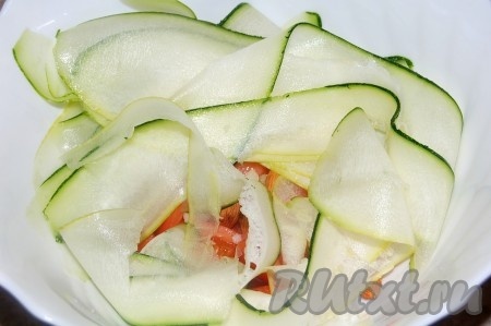 Нарезанные сырые кабачки добавить в салатницу к помидорам.
