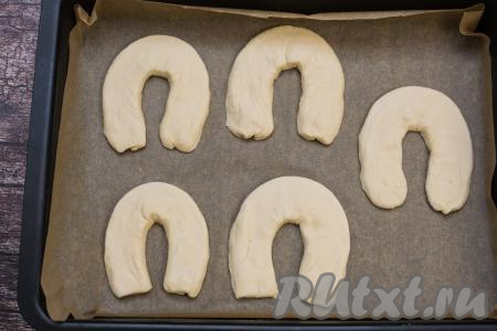 Аналогично сформировать все 5 подков из полосок слоёного теста, выложить их на противень, застеленный пергаментом.