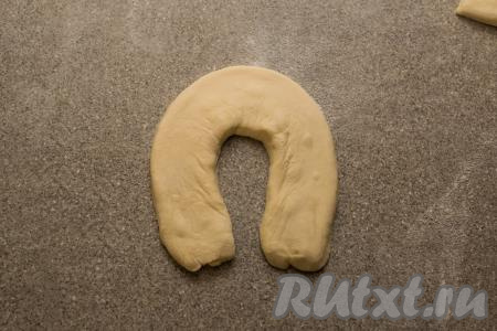 Каждую полоску теста, не раскатывая, свернуть в подкову и слегка прижать сверху рукой, чтобы тесто приняло форму подковы.