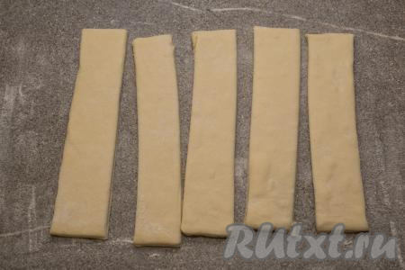 Пласт размороженного слоёного теста на припылённом мукой столе разрезать на 5 полосок.