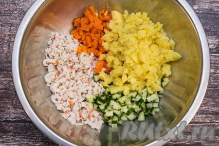 Остывшие картошку и морковку очистить. Картошку и 1 морковку тоже нарезать на мелкие кубики, выложить в миску с салатом из огурцов и крабовых палочек.