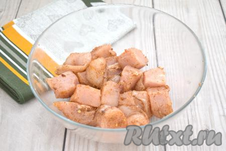 Сразу перемешиваем кусочки мяса курицы, равномерно покрывая их специями со всех сторон.