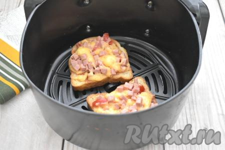 2 сформированные пиццы на тостовом хлебе возвращаем в чашу аэрогриля. Готовим в аэрогриле оставшиеся 3 минуты при температуре 200 градусов. Готовые мини-пиццы вынимаем из чаши аэрогриля. Аналогично подготавливаем и запекаем ещё 2 пиццы на оставшихся кусках тостового хлеба.&nbsp;