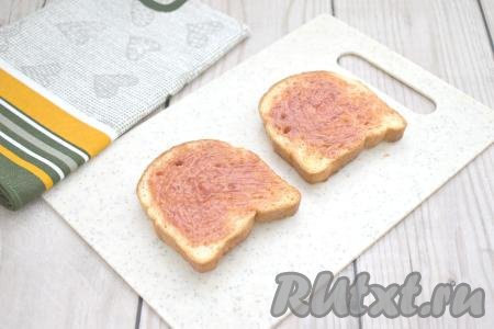 Чашу с тостовым хлебом достаём из аэрогриля. Вынимаем хлеб из чаши и хрустящей (подсушенной) стороной вниз кладём на разделочную доску. Смазываем каждый кусок хлеба 1 чайной ложкой&nbsp;томатного соуса (или кетчупа).&nbsp;&nbsp;