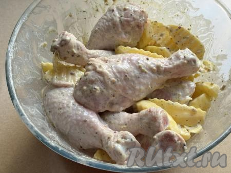 Хорошо перемешать дольки картофеля и куриные ножки, покрывая их специями и майонезом со всех сторон.