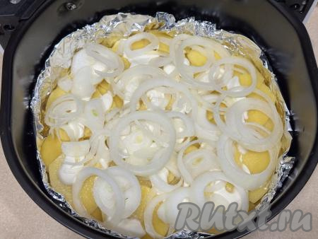 Лук нарезать на тонкие кольца, выложить поверх картошки. Влить к картошке 100 миллилитров воды.