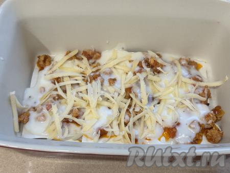 Сыр натереть на крупной тёрке. Присыпать фарш с соусом частью натёртого сыра.