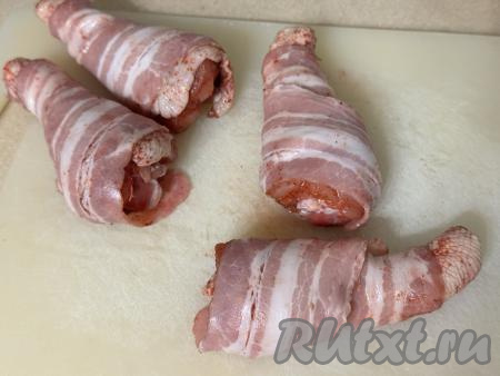 Я купила бекон, уже нарезанный на тонкие полоски. Если вы купили кусок бекона, тогда нарежьте его на тонкие полоски. Каждую куриную ножку полностью завернуть в полоску бекона, накручивая её немного внахлёст.&nbsp;&nbsp;