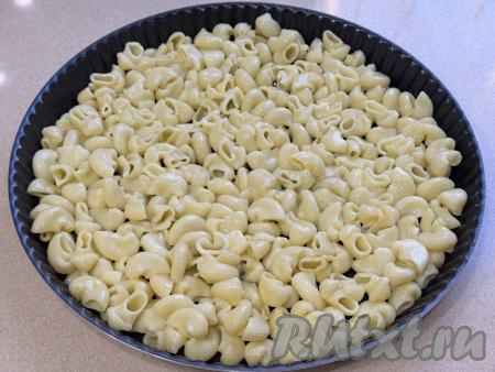 Форму для запекания (я взяла форму диаметром 26 сантиметров) немного смазать растительным маслом, выложить ровным слоем макароны, смешанные с яйцом,&nbsp;полностью закрывая всё дно.&nbsp;