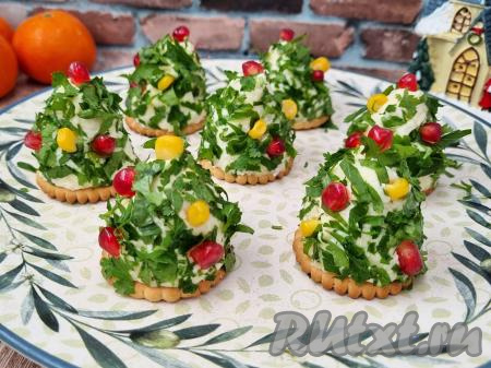 Осталось украсить сырную закуску на крекерах. Для украшения я использовала зёрна граната и зёрна консервированной кукурузы, но можно взять и ягоды клюквы, красной смородины. Можно выбрать и что-то одно, например, только кукурузу или гранат. На каждую ёлочку разместить по несколько зёрен граната и кукурузы. Мне очень нравится сочетание сырной закуски и граната. Я купила розовый гранат, он достаточно сладкий, поэтому вкус зёрен граната очень обогатили вкус ёлочки из сыра.