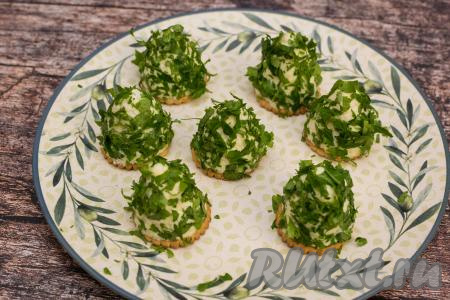 Установить сырные ёлочки, обваленные в зелени, на плоскую тарелку.