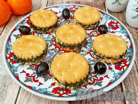 Сформированные бутерброды на крекерах с начинкой из сыра и яиц выложить на плоскую тарелку и поставить в холодильник, как минимум, на 2 часа, чтобы крекеры успели хорошо пропитаться и стать более мягкими.&nbsp;По прошествии времени закуску на крекерах можно выкладывать на красивое блюдо и подавать на праздничный стол. Уверена, эта вкусная, аппетитная порционная закуска понравится многим!