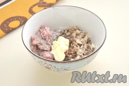 Для этого блюда можно взять фарш из любого мяса (например, из свинины, курятины, говядины или индейки). Фарш можно приготовить в домашних условиях, прокрутив кусочки мяса через мясорубку, или использовать покупной фарш. Выкладываем фарш в достаточно глубокую миску, добавляем майонез, мелко нарезанные ножки шампиньонов и мякоть, которую мы вынули из шляпок, перчим, солим по вкусу.