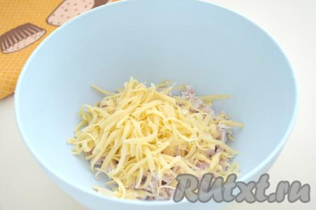 В миску с куриным мясом добавляем сыр, натёртый на крупной тёрке.