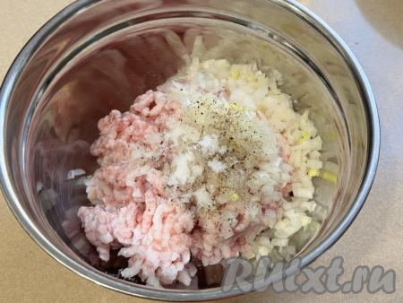Лук и чеснок очистить, измельчить в измельчителе (или пропустить через мясорубку), добавить в миску с фаршем, всыпать соль и чёрный молотый перец.&nbsp;